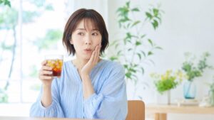 冷たい飲み物で歯がしみる女性(知覚過敏のイメージ)