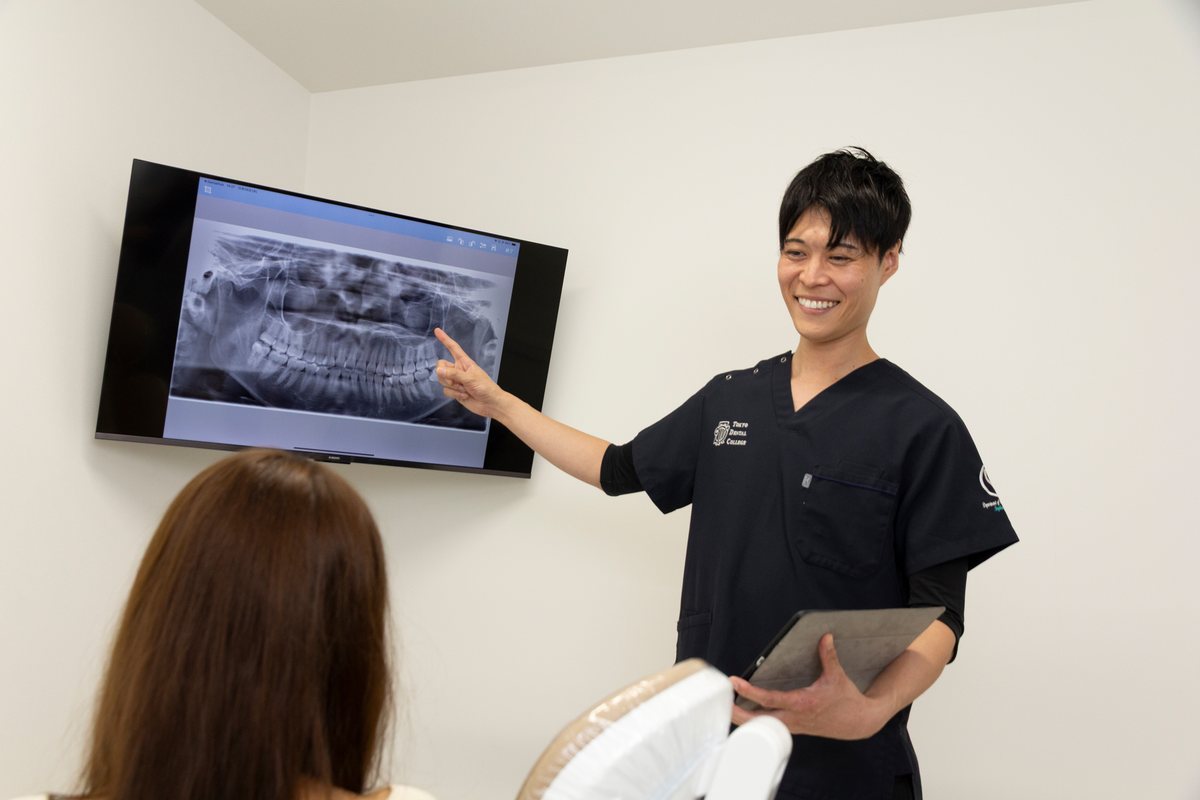 レントゲン画像を見せながら説明する院長